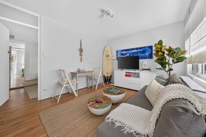 Een moderne woonkamer met een bank, salontafel en een televisie.