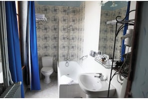 A bathroom with a toilet, bathtub, and sink.