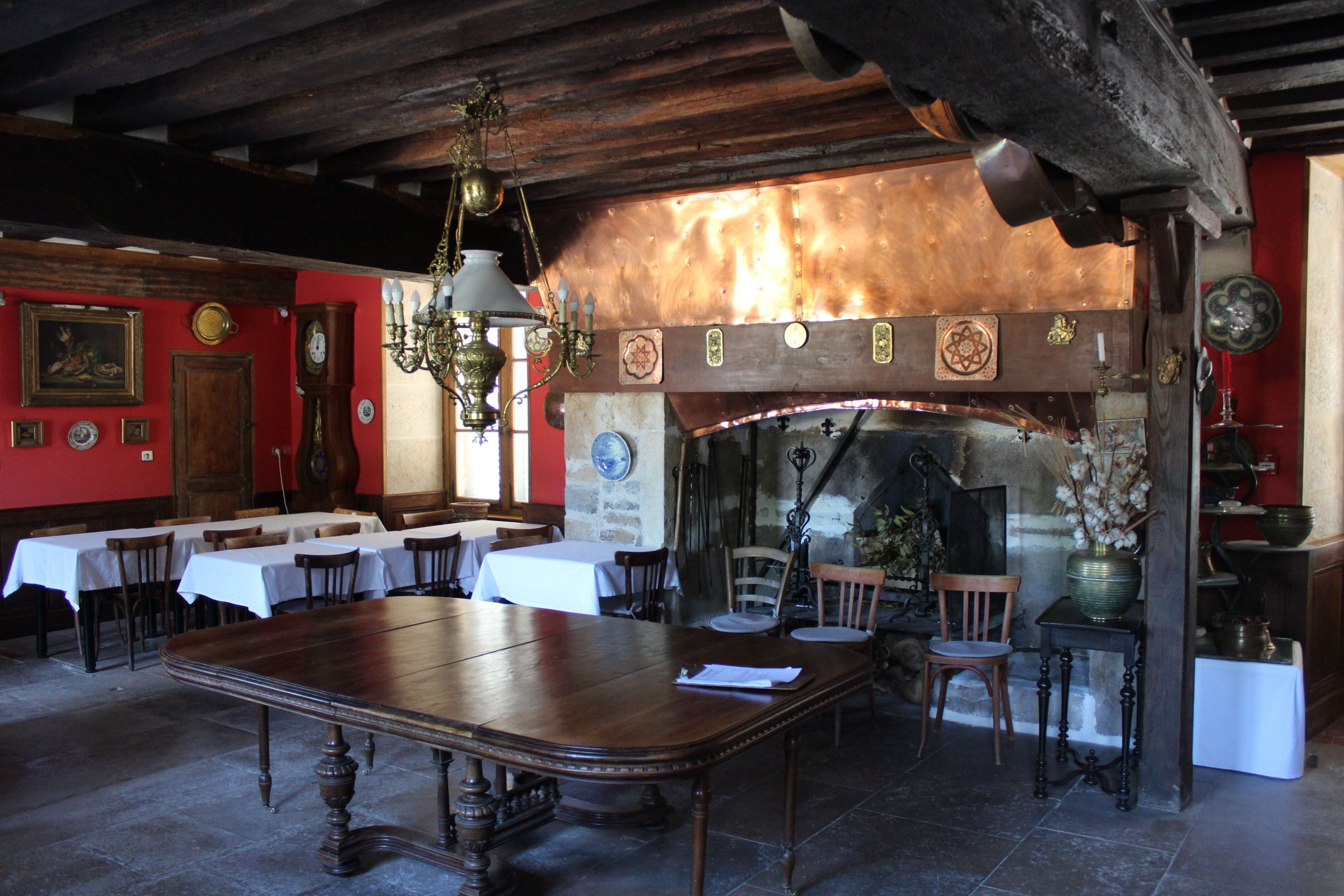 Un restaurant avec des tables et des chaises en bois, un lustre et un décor rustique.