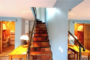 Una escalera con barandilla de madera que lleva a una plataforma.