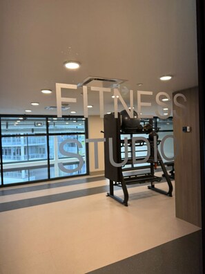 A fitness studio with exercise equipment, large windows, and a ceiling with recessed lighting. - Waterfront Bliss | Luxury 1BR & 1BATH (sleep up to 4) (Kelowna)