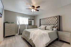 A bedroom with a bed, a nightstand, a dresser, a ceiling fan, and a window with curtains. - Spacious & tranquil 4-bedroom house 20min Airport, Fort Sam &Downtown SanAntonio (San Antonio)