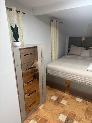 Un dormitorio con cama, armario y planta en maceta.