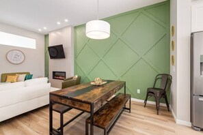 A modern kitchen with a dining table, bench, and a green accent wall. - +Sleeps15 | 2Kitchens | 3 FamilyRooms | 5FullBaths (Calgary)