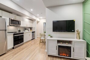 A modern kitchen with a built-in microwave, oven, and a fireplace. - +Sleeps15 | 2Kitchens | 3 FamilyRooms | 5FullBaths (Calgary)
