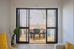 A room with a sliding glass door leading to an outdoor patio area. - Sun & Golf Vilamoura Boutique Apartment (Quarteira)