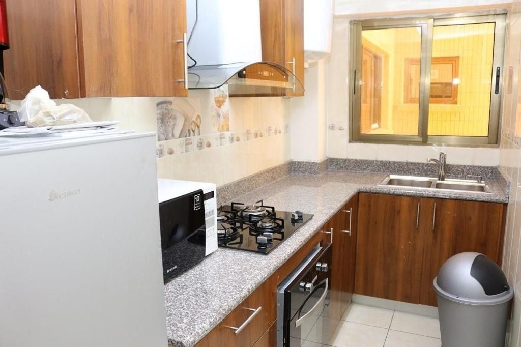 A compact kitchen with a gas stove, oven, and a stainless steel sink.