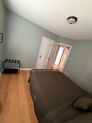 A room with a bed, a door, a radiator, and a window. - Hoosier House - Cozy 2BR Indy Stay Near Everything (Indianapolis)