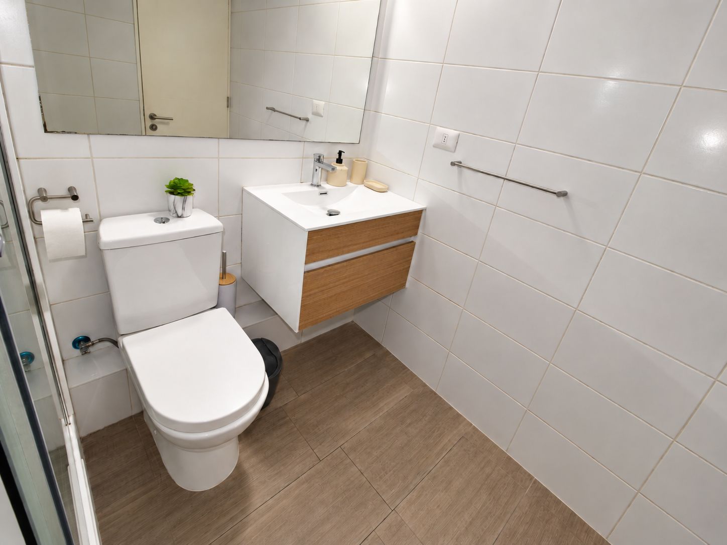 Une salle de bain moderne avec des toilettes, un lavabo et un miroir.