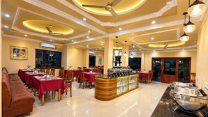 A hotel lobby with a central bar area, multiple dining tables, and a seating area with a sofa. - The Orchid Phuentsholing (Phuntsholing)
