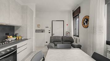 A compact kitchen with a stove, oven, and a dining area with a table and chairs.