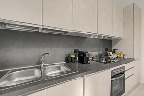 A modern kitchen with stainless steel appliances, a double sink, and a built-in oven.