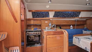 Une petite cuisine équipée avec une cuisinière, un évier et des placards de rangement.