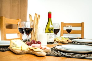 Ein gedeckter Tisch mit Käse, Crackern, Trauben und Weingläsern.