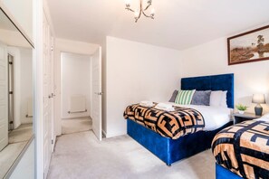 A bedroom with a bed, bedside tables, a lamp, and a painting on the wall. - Argus 4-Bed Premium in Hemel: Contractor, Families (Hertfordshire)