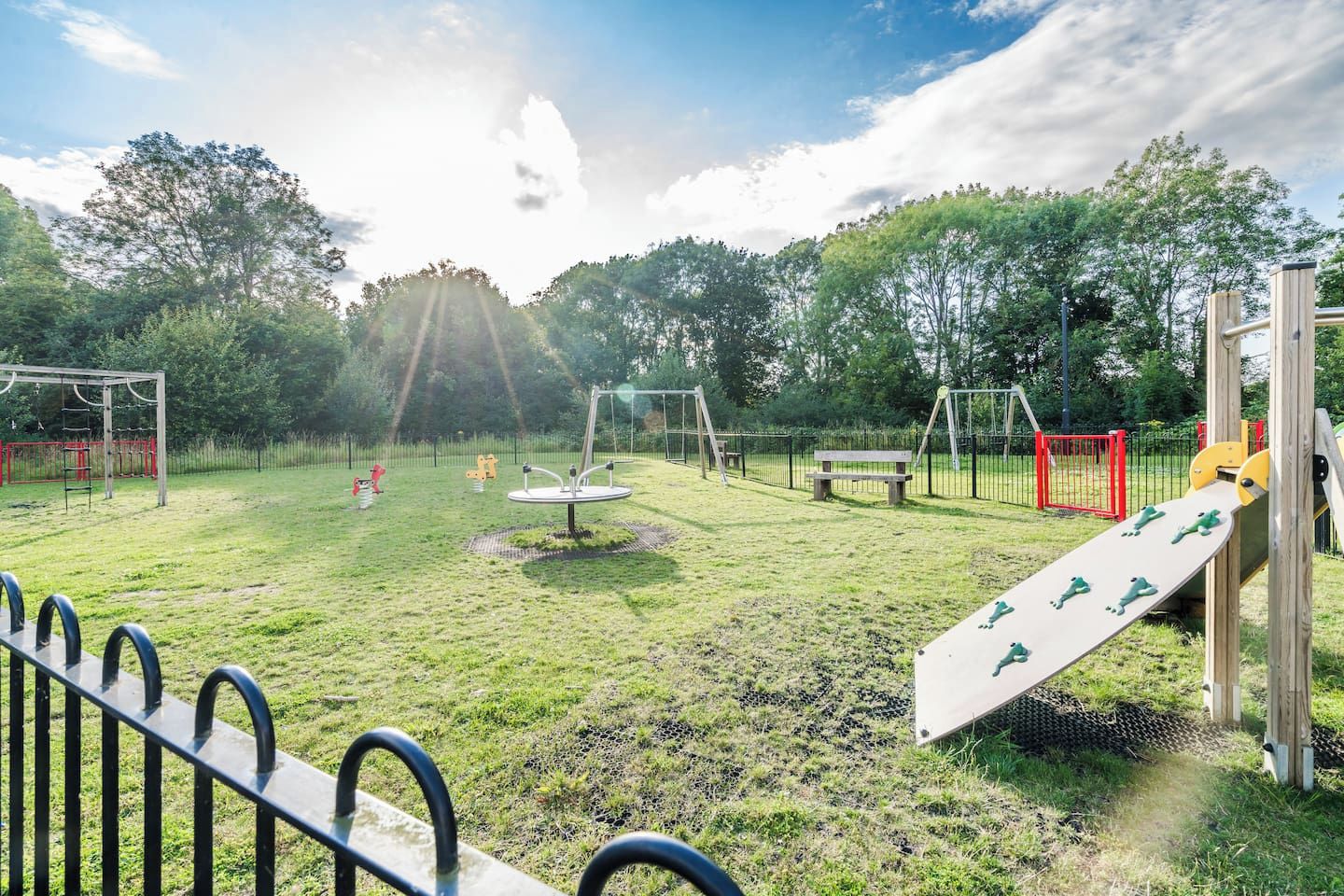 A playground with various play equipment, including swings, a slide, and climbing structures.
