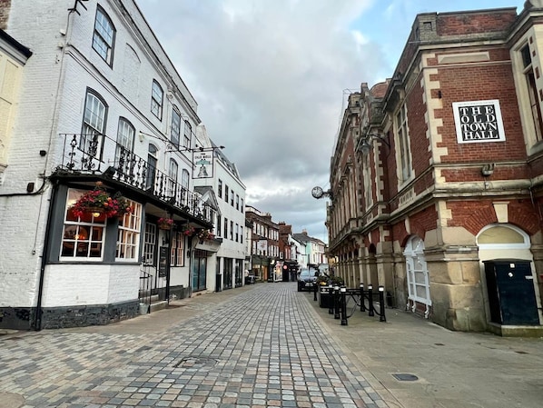 A cobblestone street lined with historic buildings, including a pub with a sign reading 'Old Bell.' - Argus 4-Bed Premium in Hemel: Contractor, Families (Hertfordshire)