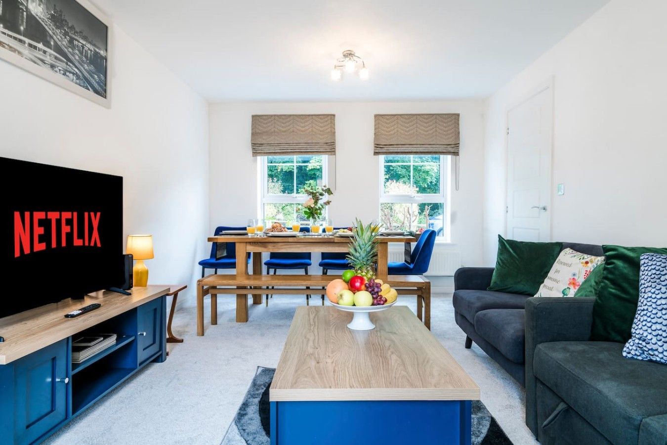 A living room with a TV, dining table, and a couch.