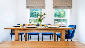 A dining area with a wooden table, blue chairs, and a bench.
