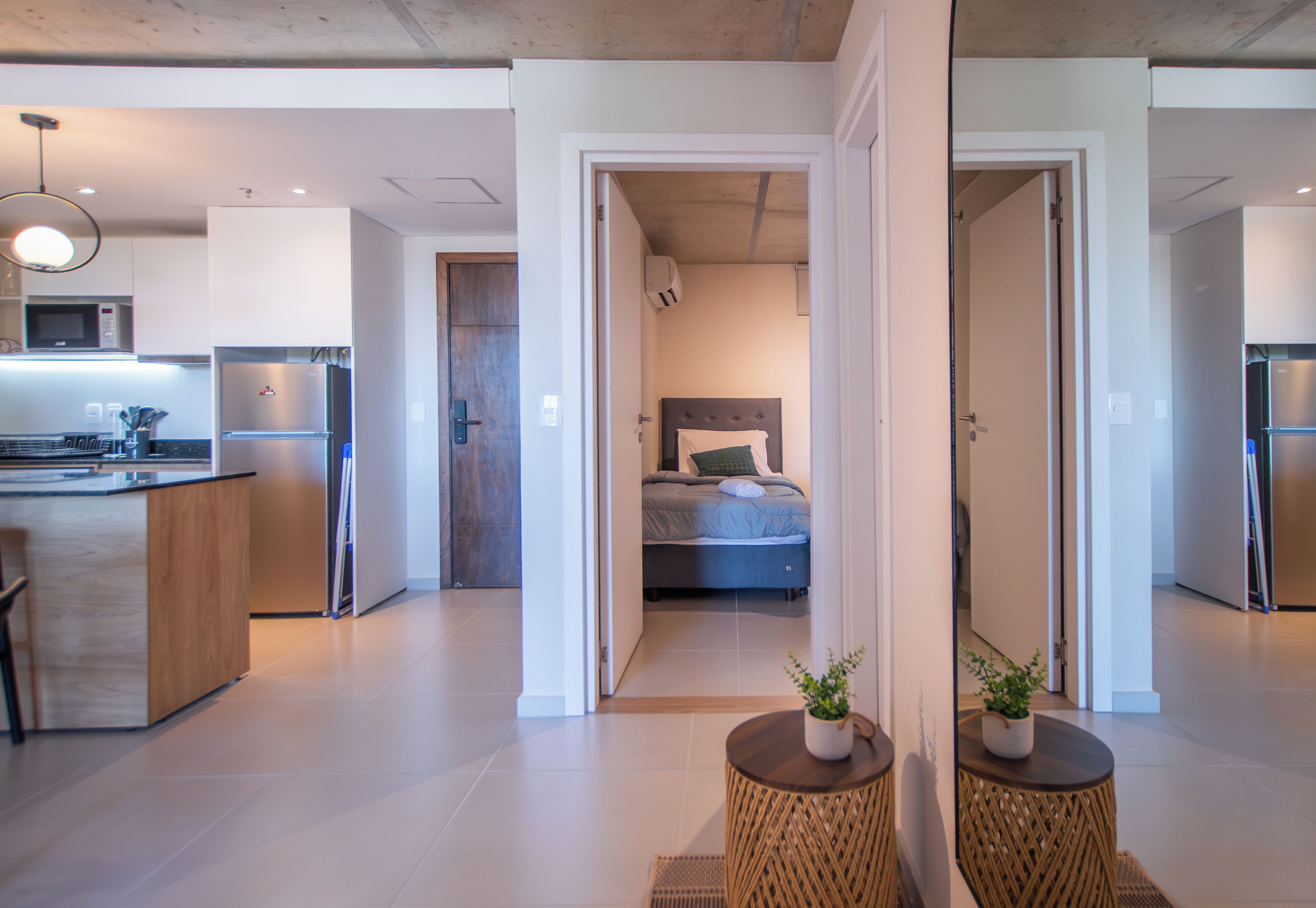 A modern apartment with a kitchen, a bedroom, and a living area.