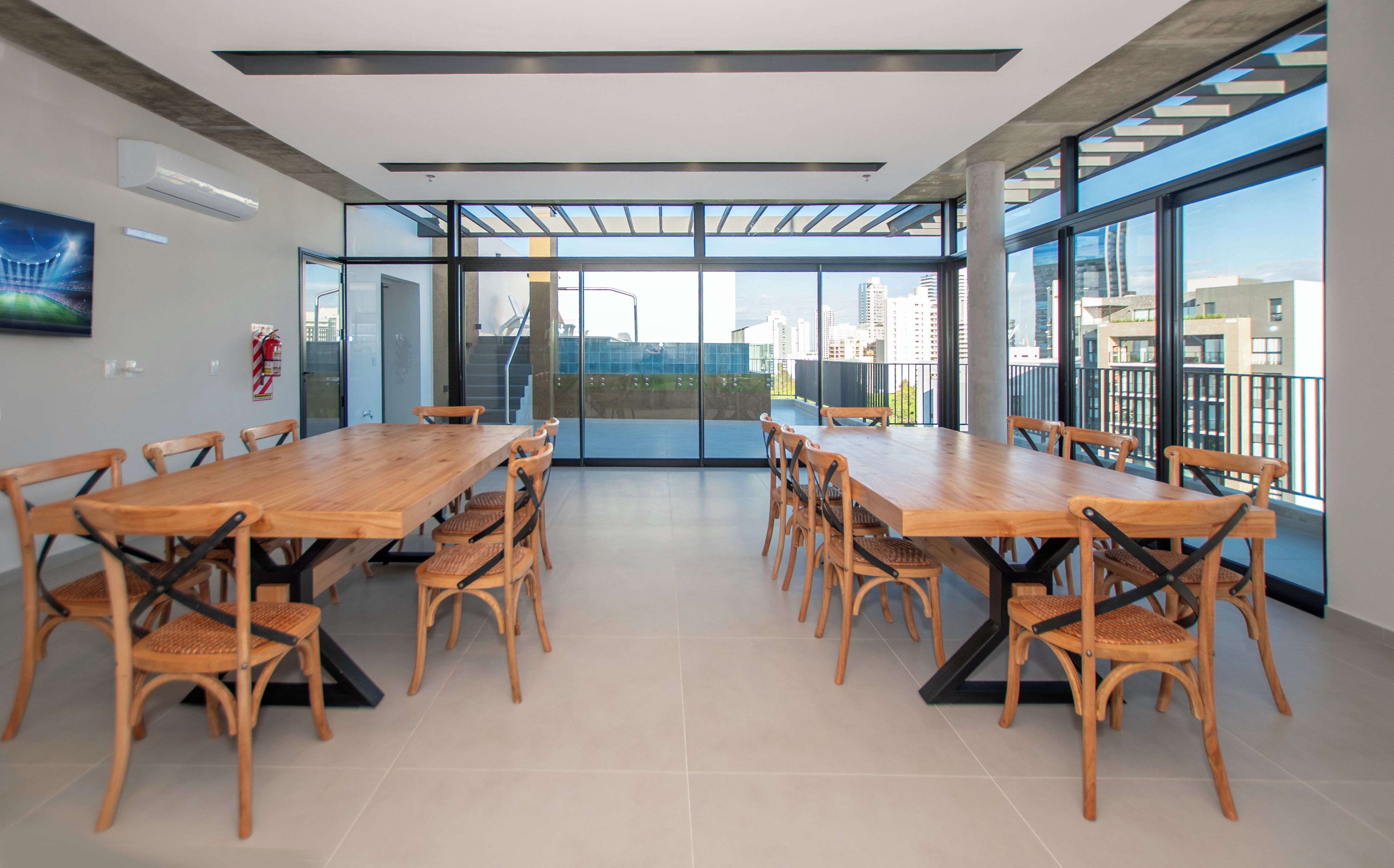 A conference room with a long table and chairs, large windows, and a view of the cityscape.