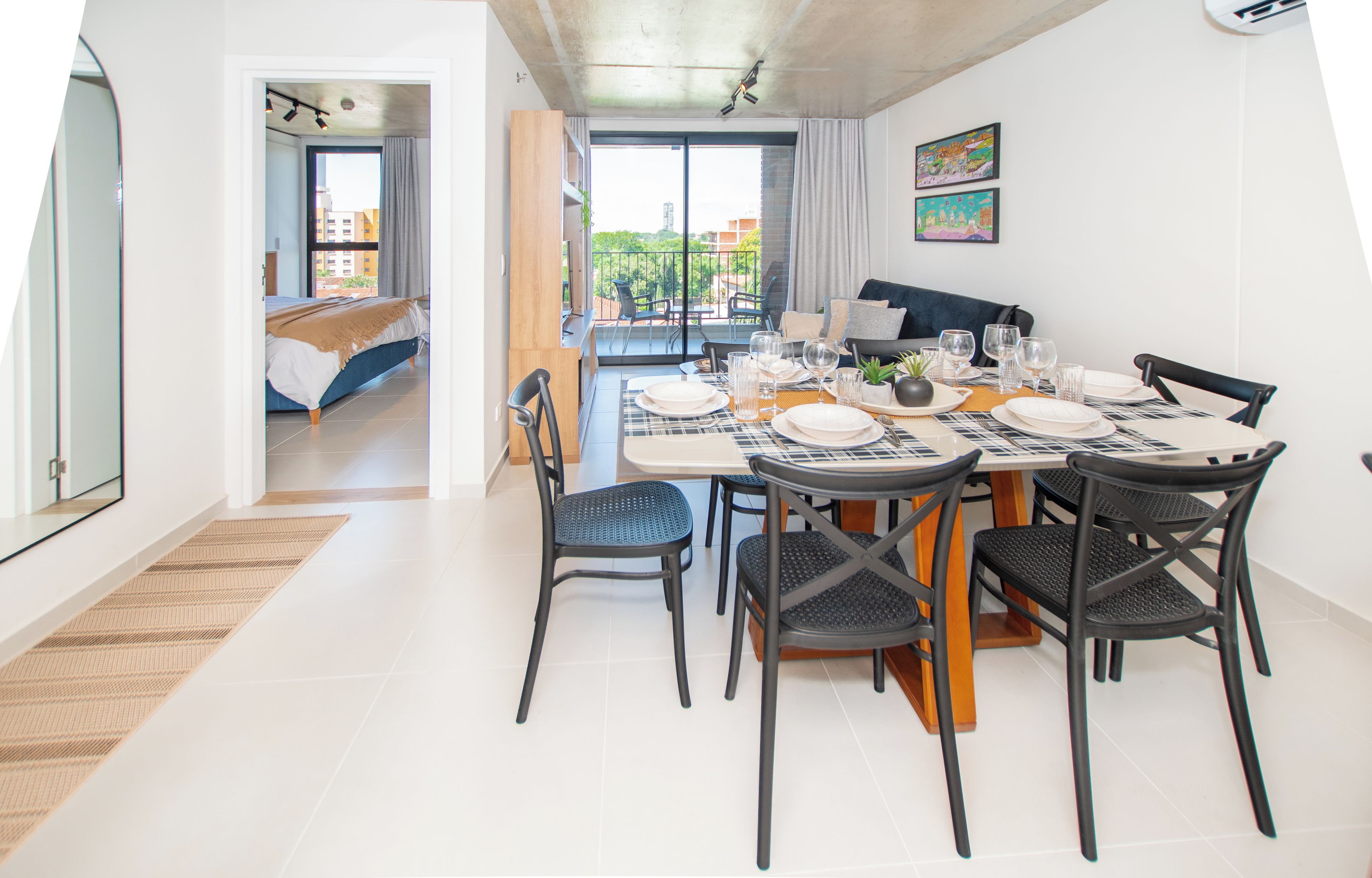 Un comedor moderno con una mesa dispuesta para seis personas, sillas y vistas al exterior.