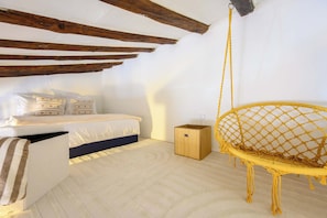 A bedroom with a bed, a hanging chair, and a small wooden box. - Cosy Joffre - loft et mezzanine, Croisette à 5 min (Cannes)