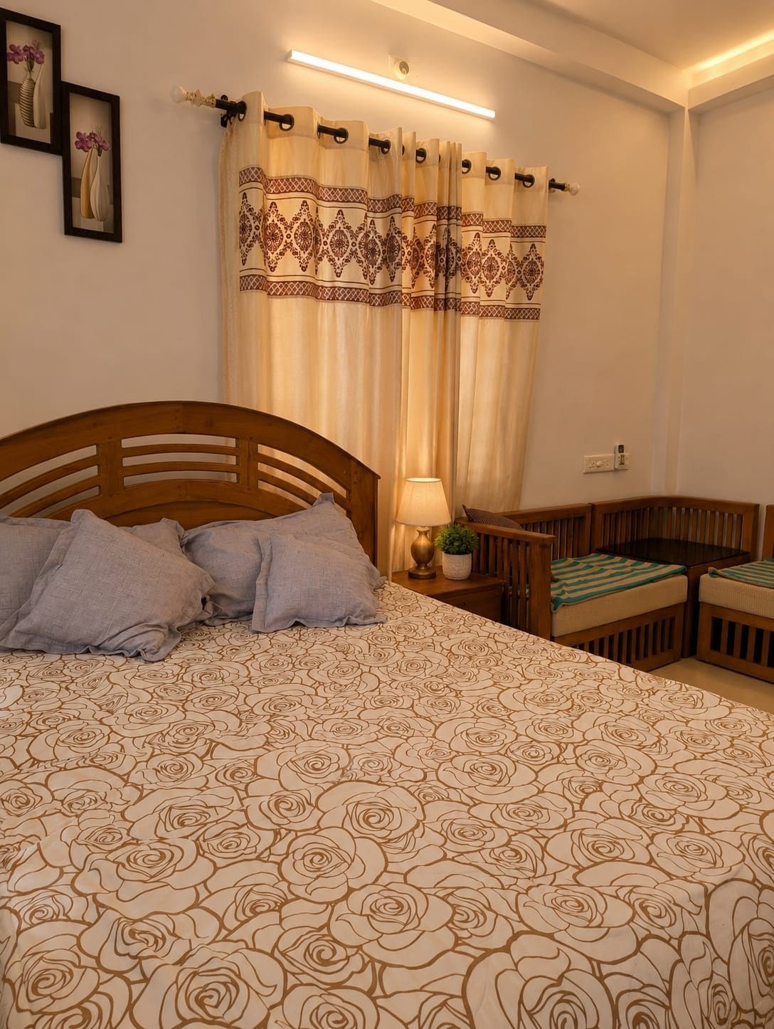 Un dormitorio con una cama grande, una mesita de noche con lámpara, una silla y una pequeña mesa.