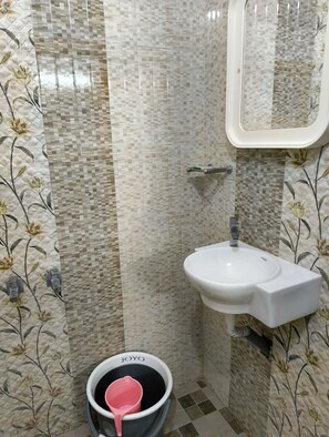 Ein Badezimmer mit gefliesten Wänden, einem Waschbecken und einer Toilette.