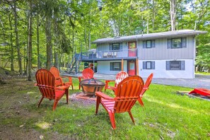 A two-story cabin with a deck and a fire pit area with chairs. - Pocono Cabin w/ Fire Pit, Kayaks & Lake Access (Big Bass Lake)