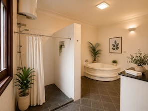 Un baño con ducha, bañera y zona de lavamanos.
