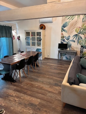 A dining area with a wooden table and chairs, a television on a stand, and a sofa. - Family home in Tarascon in the countryside: walks, relaxation, and a warm, friendly atmosphere  (Tarascon)