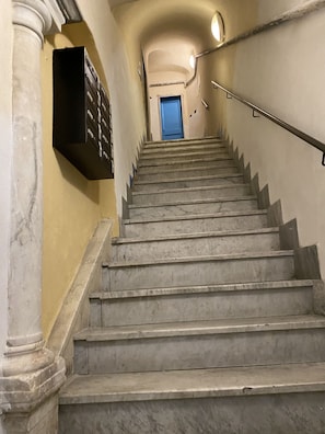 A staircase with marble steps leading to a blue door at the top. - Casa dei Fregoso | Cozy apartment, 5 minutes from the aquarium (Genova)