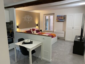 A compact hotel room with a bed, a desk, and a dining area. - Casa dei Fregoso | Cozy apartment, 5 minutes from the aquarium (Genova)
