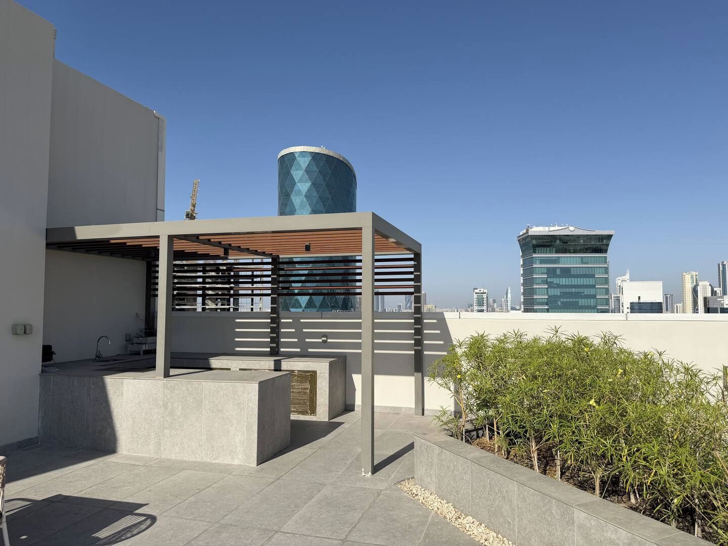 Une terrasse sur le toit, agrémentée d’une pergola, d’un espace salon et offrant une vue sur le panorama urbain.