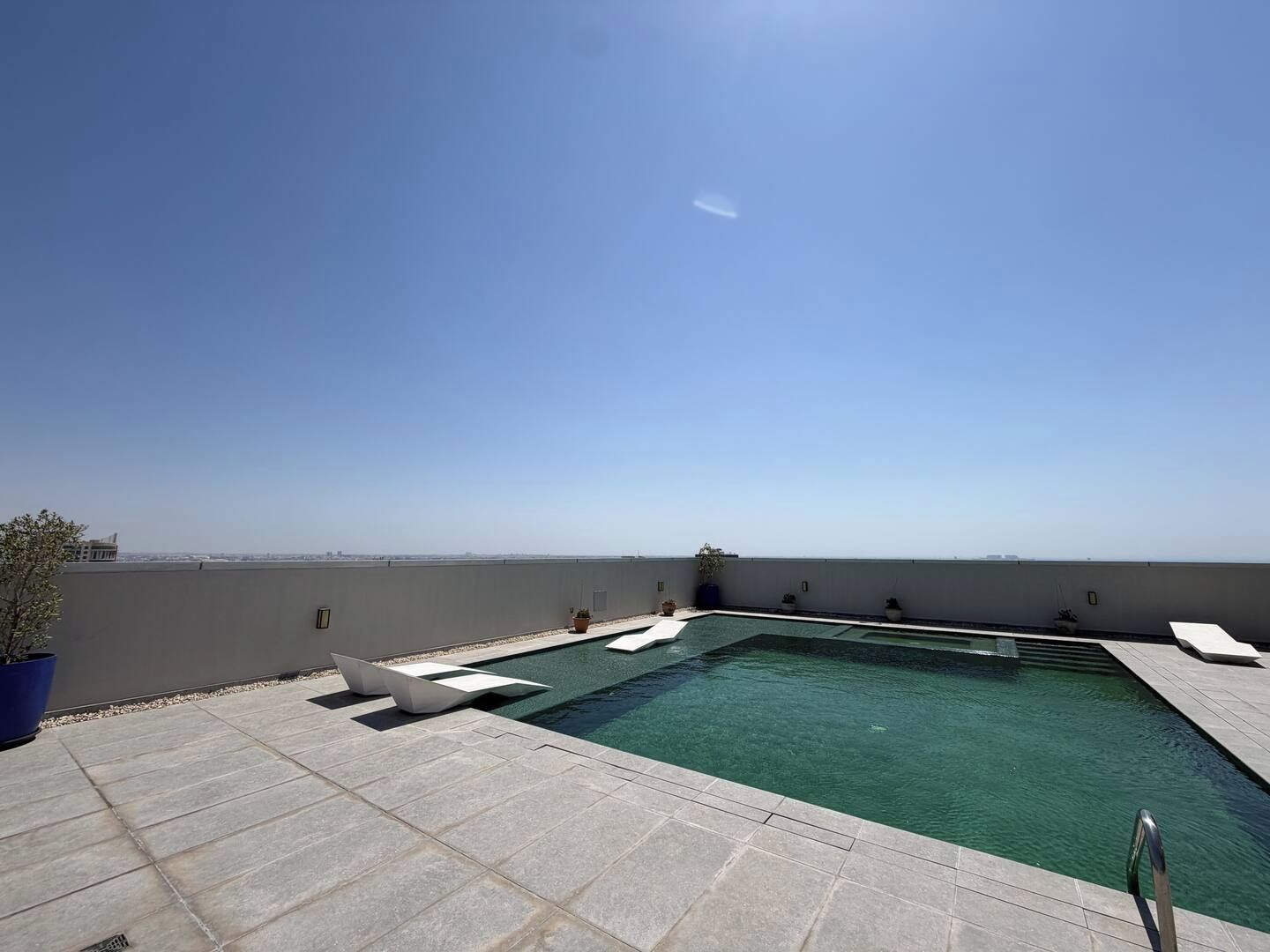 Una piscina en la azotea con vistas despejadas al horizonte de la ciudad.