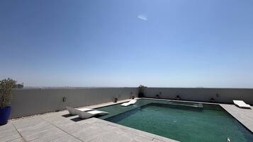 Una piscina en la azotea con vistas despejadas al horizonte de la ciudad.