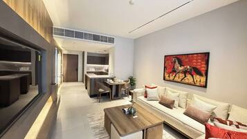 A modern living room with a sofa, coffee table, and a painting on the wall.