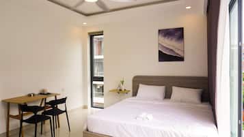 Un dormitorio con cama, escritorio y sillas.