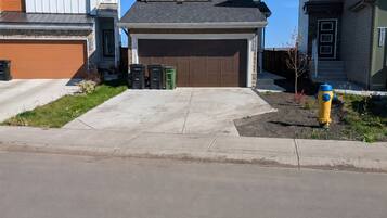 A residential street with houses featuring modern architecture, a garage, and a fire hydrant.
