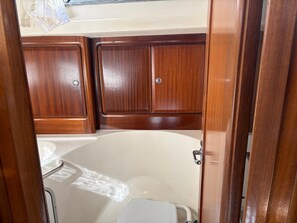 Un bagno con una vasca da bagno bianca, mobili in legno e un water bianco.