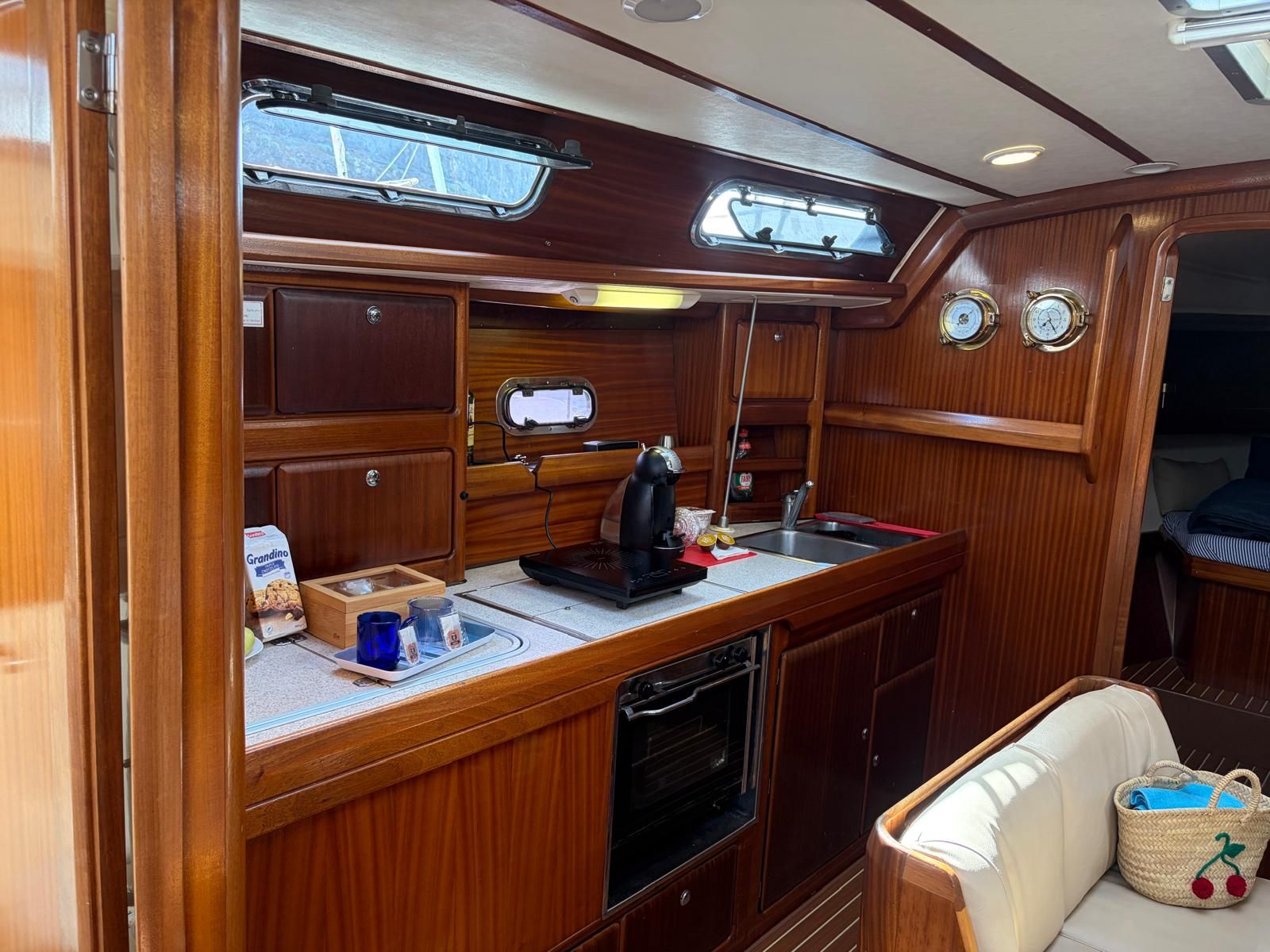 A compact galley with a sink, stove, and storage cabinets.