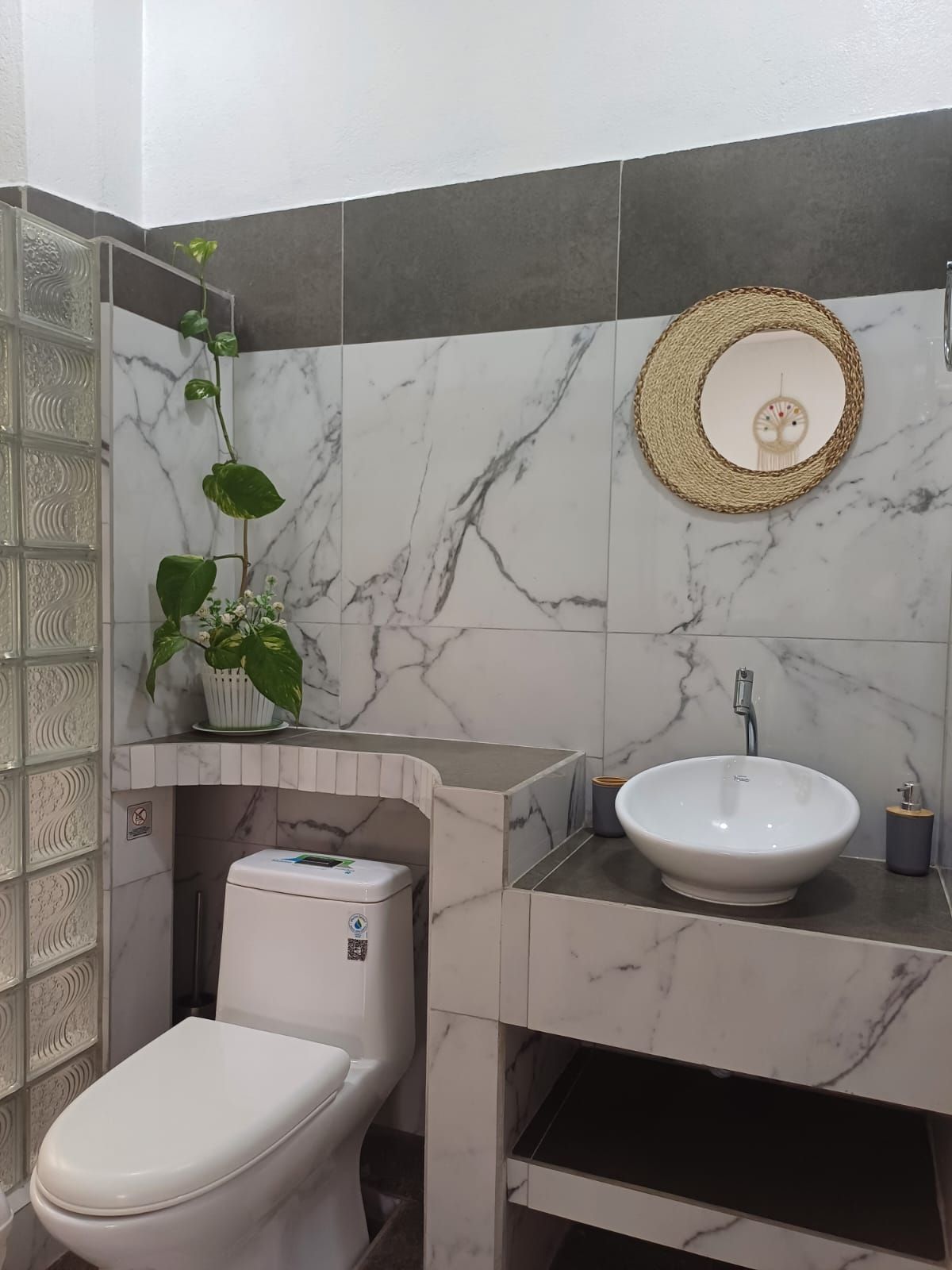 Un baño con inodoro, lavabo y espejo.