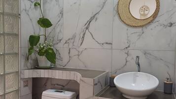 Un baño con inodoro, lavabo y espejo.