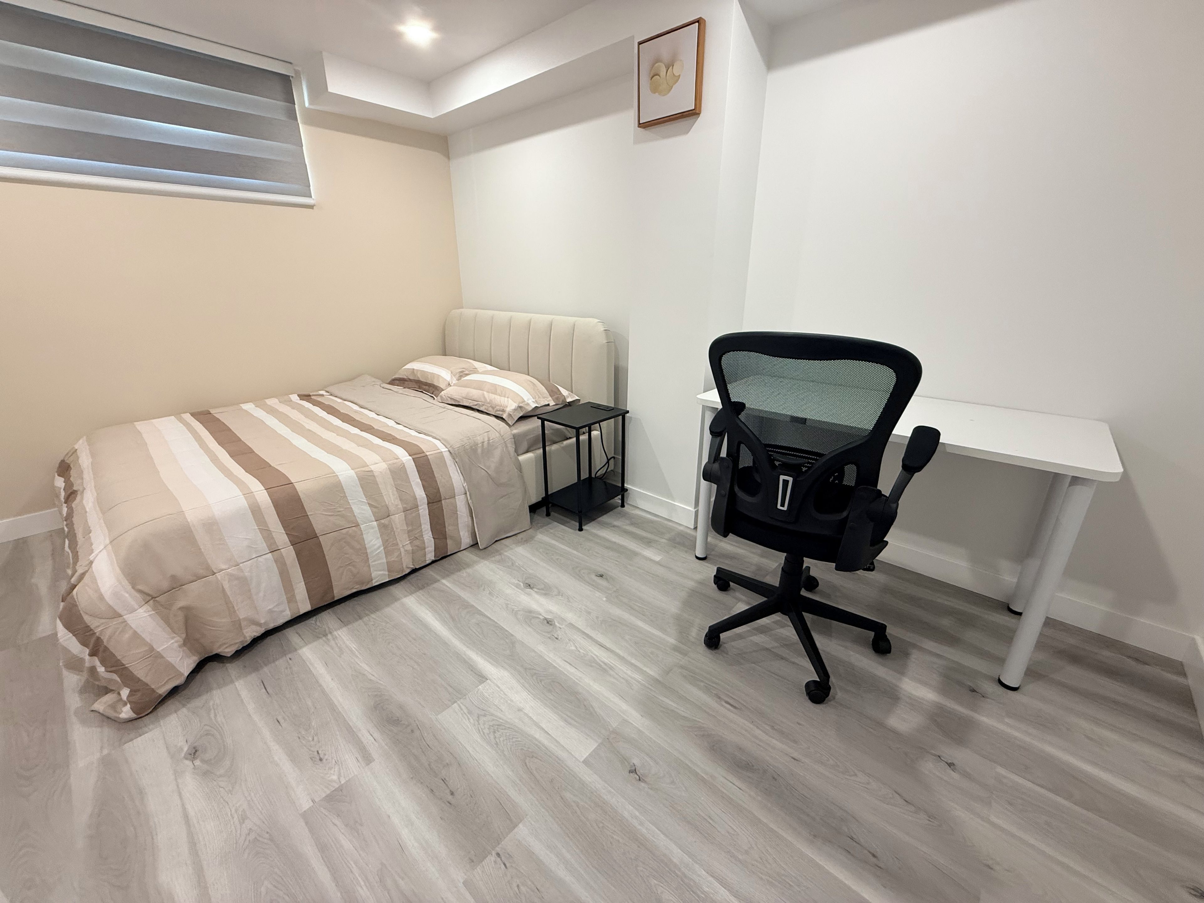 Ein Schlafzimmer mit einem Bett, einem Schreibtisch und einem Stuhl.