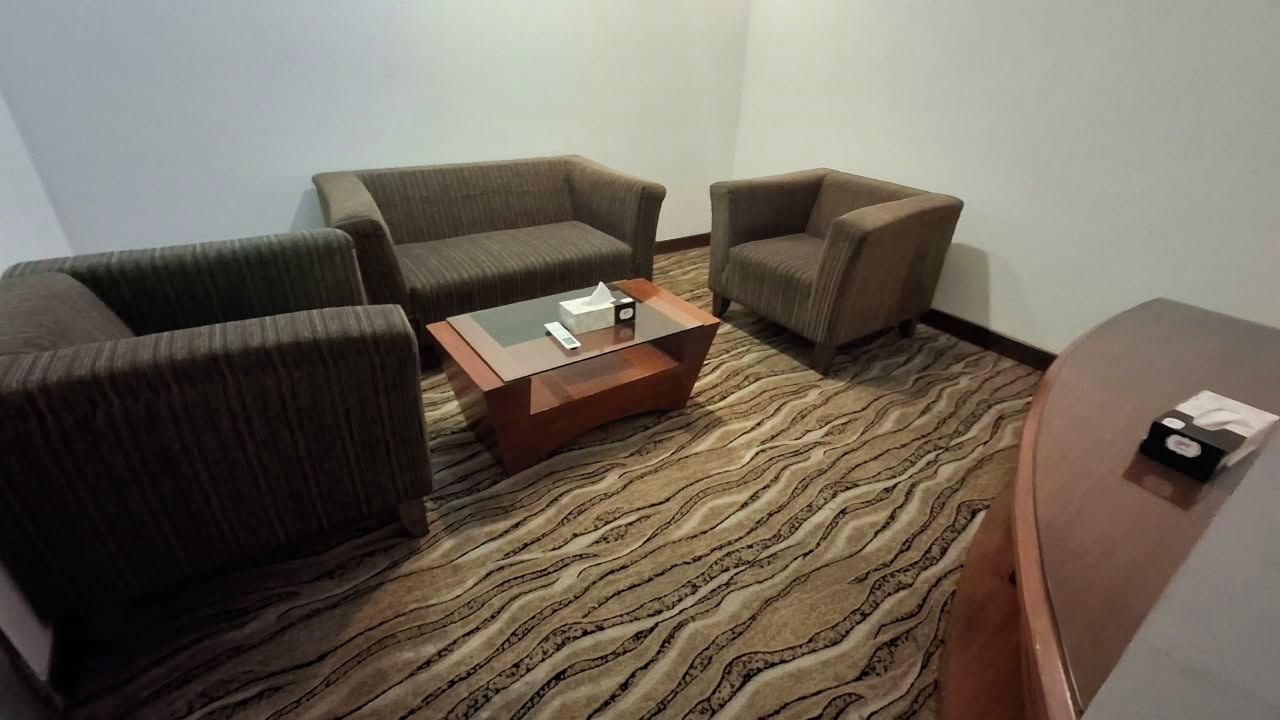 A room with a sofa, armchairs, and a coffee table.