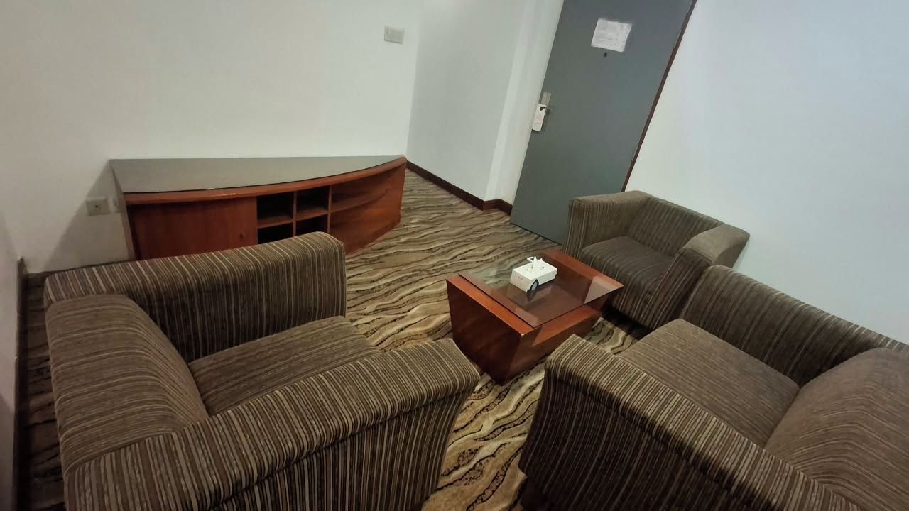 A room with a sofa set, a wooden coffee table, and a carpeted floor.