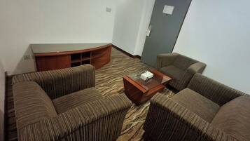 A room with a sofa set, a wooden coffee table, and a carpeted floor.
