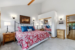 A bedroom with a large bed, bedside tables, a mirror, and a wooden dresser. - Spacious Breckenridge Townhome, Community Hot Tub (Breckenridge)