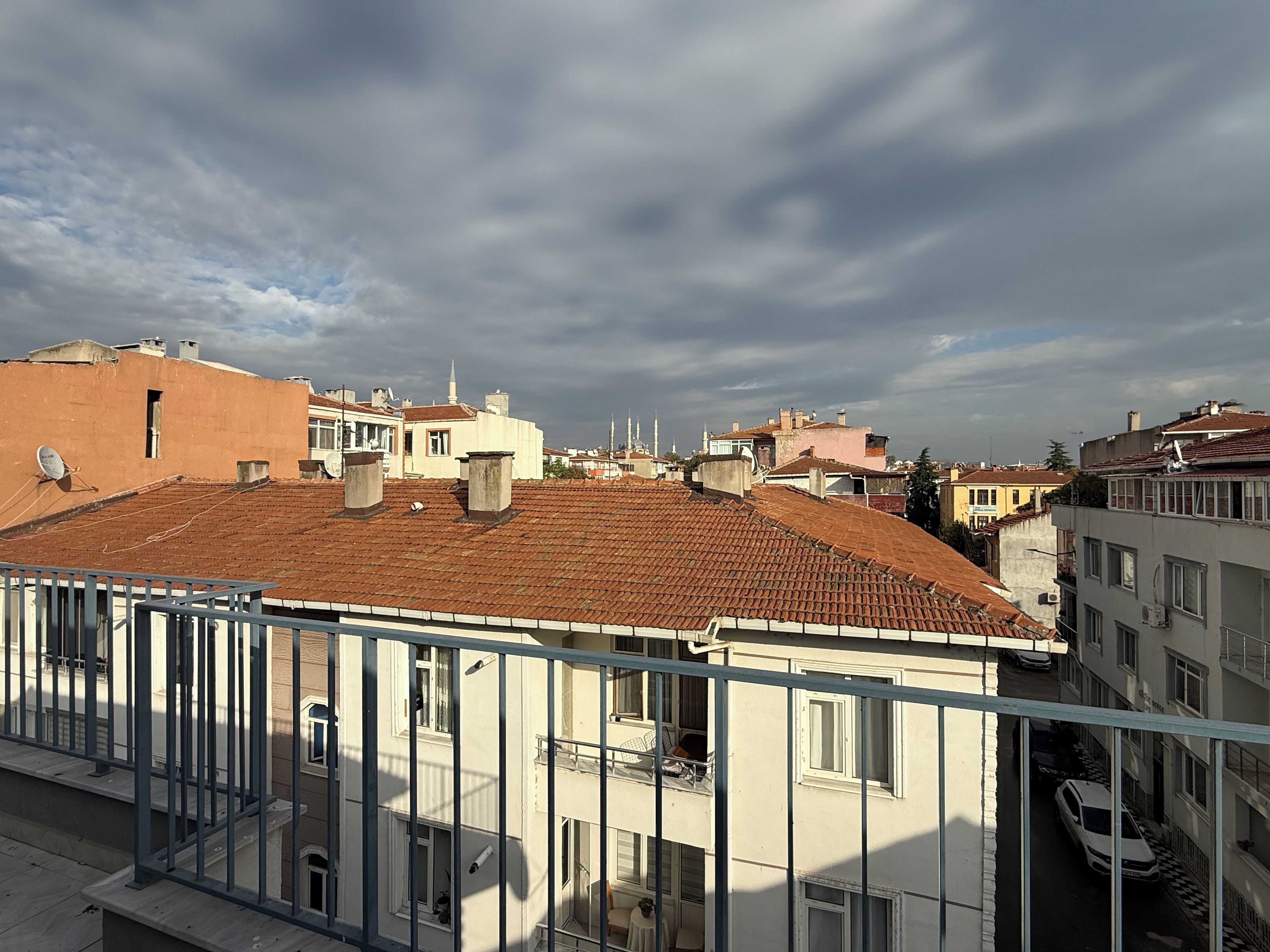 Un barrio residencial con tejados de tejas color terracota, balcones y cielo despejado.